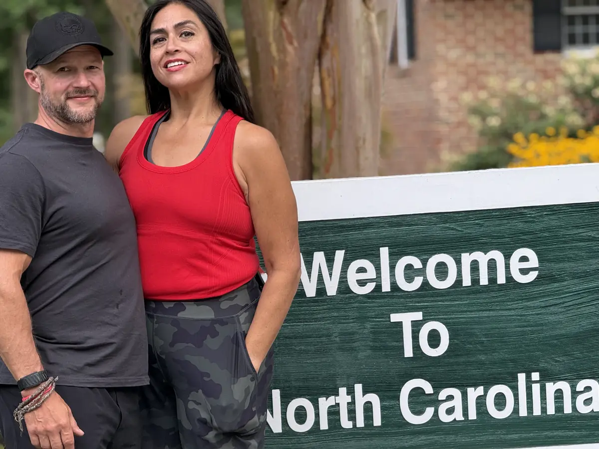 Yaya and Casey McBride standing together outdoors, smiling.