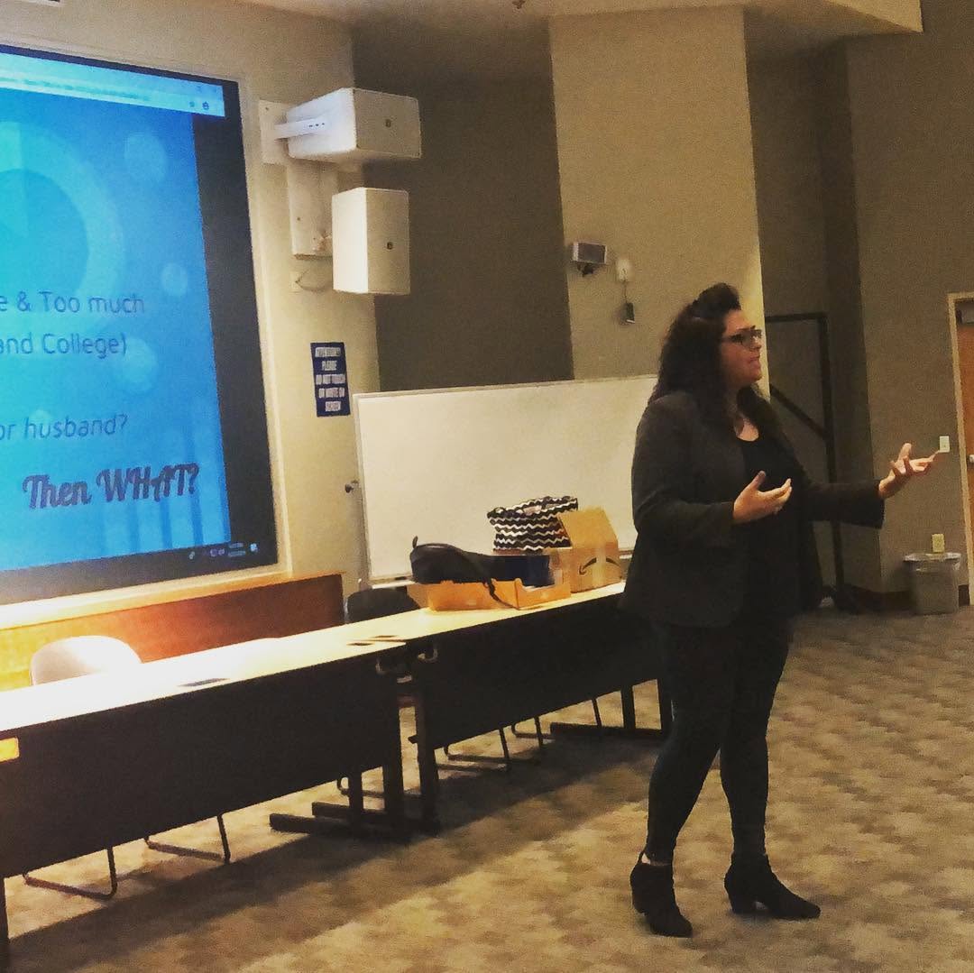 Yamile "Yaya" McBride speaking to a classroom of college students, mid-gesture.